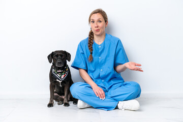 Young veterinarian woman with dog sitting on the floor isolated on white background making doubts...