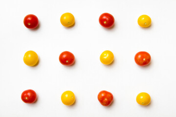 Red and yellow cherry tomatoes pattern on white background. Flat lay. Top view.