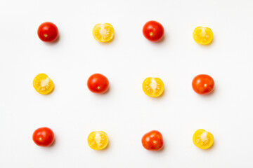 Red and yellow cherry tomatoes pattern on white background. Flat lay. Top view.