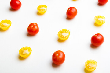 Red and yellow cherry tomatoes pattern on white background. Flat lay. Top view.