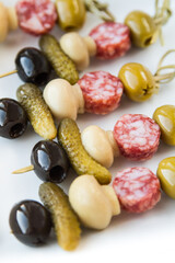 Canape on bamboo skewers on a white background/