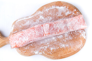 Raw salmon in flour on the wooden cutting board