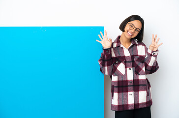 Young mixed race woman with a big blue placard isolated on white background counting nine with...