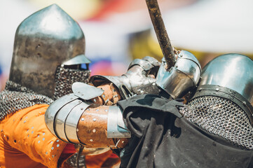 Pitch battle of medieval knights, using metal armor, axes, swords and shields to defend themselves.