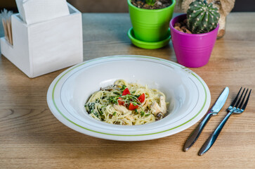 Pasta with chicken meat, mushrooms, spinach and cream sauce.