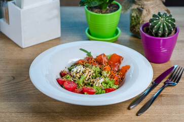 Salad with salted salmon with cherry tomatoes, cream cheese, lettuce and sesame seeds.