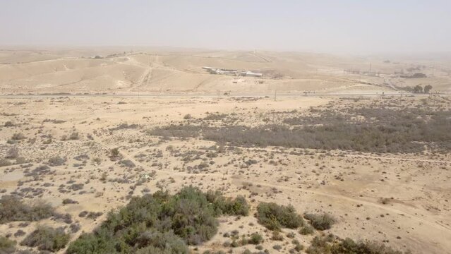 Flight to direction of agriculture farm on hills in desert Negev at sand storm time