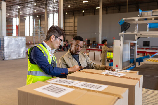 Asian mid adult manager holding checklist and discussing with african american young ,male worker