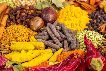 Fototapeta premium Various spices, peppers and herbs close-up top view. Eastern spice market. A set of peppers and spices for cooking.