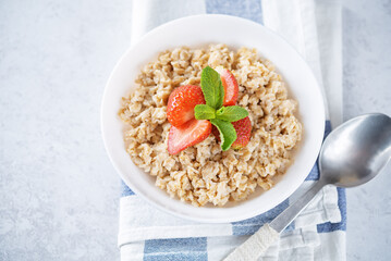 Oatmeal porridge with strawberries in a bowl