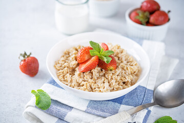 Oatmeal porridge with strawberries in a bowl