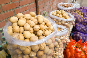 Street market colorful bags and baskets full of walnuts on local store exterior display