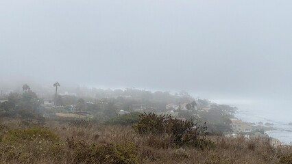View of El Matador State Beach and nearby coastland in Southern California with fog rolling in from...