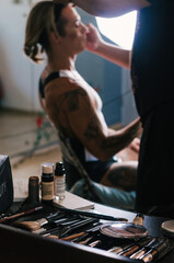 Makeup and cosmetics set, in the background makeup artist doing makeup on a man