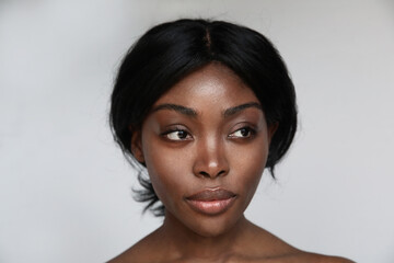  African American young woman with clean healthy skin looking aside. Isolated.