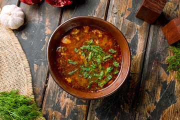 soup kharcho on brown bowl top view on wooden table