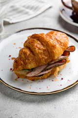 croissant with pastrami on plate on grey table macro close up vertical