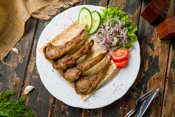 Rack of lamb on plate on wooden table top view