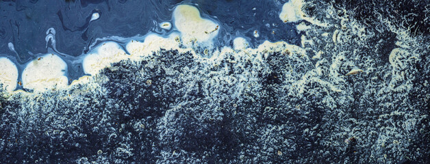 Abstract patterns on puddles of asphalt road.