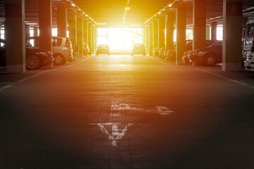 Sun shining on the cars parked in garage under the building