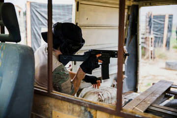 Soldier aiming airsoft gun during tactical game