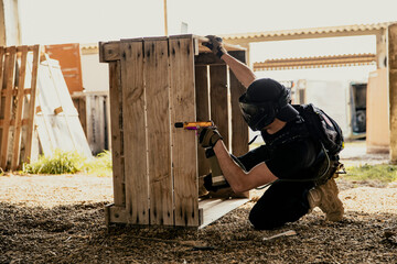 Soldier aiming airsoft gun during tactical game