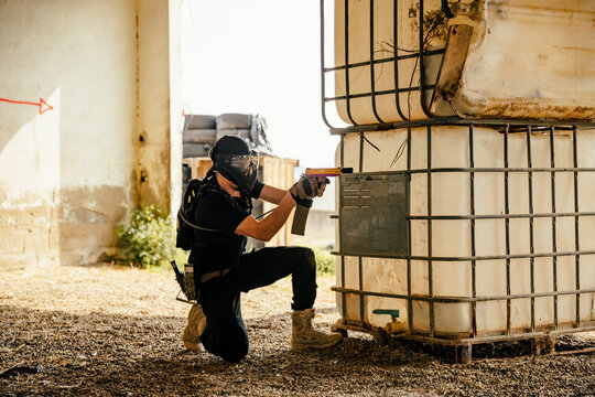 Soldier aiming airsoft gun during tactical game