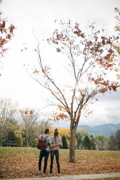 Couple holding eachother outside on an autumn day surrounded by 