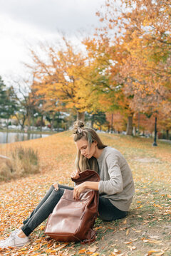 woman wearing neutral colors sitting outside in the fall looking