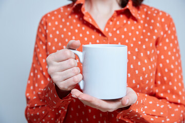 blue and white cup in the hands of a close-up. Mockup. Copy space