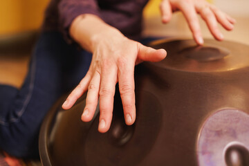 close-up, hands playing a percussion musical instrument