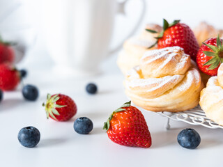 Profiteroles with powdered sugar and fresh berries.