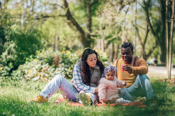 Diverse family blowing soap bubbles in park