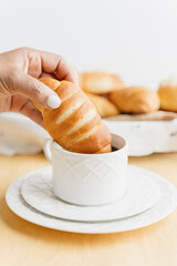 Unrecognizable woman dipping homemade Guatemalan sweet bread in a cup of coffee