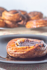 Sweet puff pastry stuffed with jabuticaba jam on a black dish with soft light