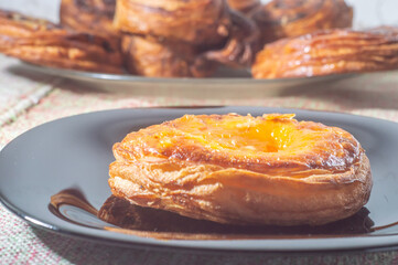 Sweet puff pastry stuffed with apricot and peach on a black dish with soft light