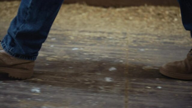 Farmer legs walking cowshed building closeup. Livestock owner inspecting barn