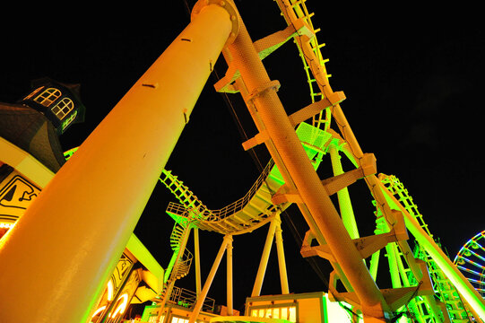 graphic image of a lit up rollercoaster at night