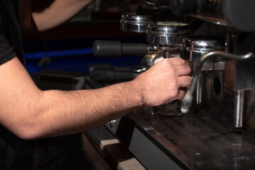 Utilizando una maquina de café. Horizontal. Color.