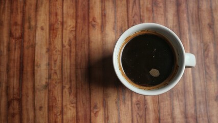 Top view of a fresh black coffee on wooden textured background. A copy space.
