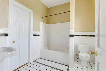 Interior historic home soaking tub black and white tile flooring