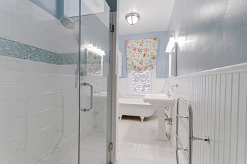 Blue and white traditional historic white clawfoot tub white pedestal sink vintage curtains and built in floating shelves 