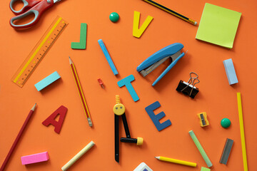 Different stationery on orange table background, flat lay. Space for text, back to school concept
