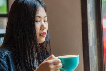 Beautiful fashion asian women hold coffee cup sitting in cafe