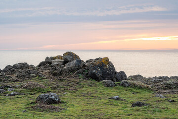 rocky cliffs edge over ocean sunset