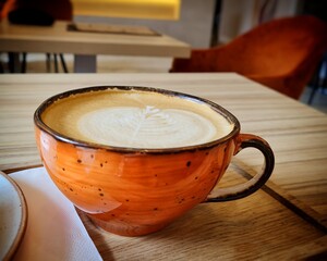 Cup of cappuccino on a wooden tray and on the table
