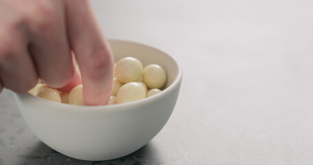 man hand take yogurt covered berries from white bowl with copy space