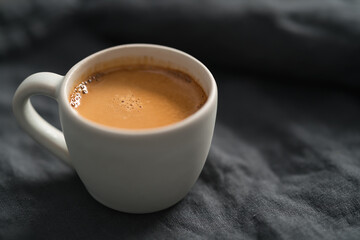 hot espresso in white cup on linen cloth with copy space