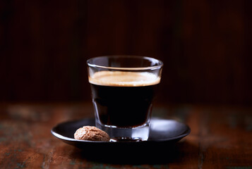 Coffee in glass cup on dark wooden background. Close up.