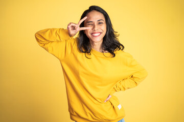 Young asian woman with peaceful hand gesture on isolated background